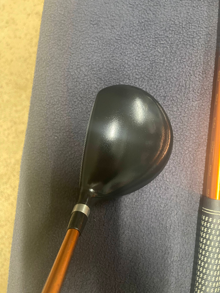 Clean black fairway wood club head on a dark towel after professional golf club detailing